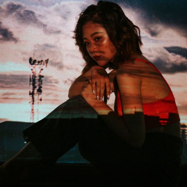 Woman in a dynamic cardio pose against a dark background with pink light trails.